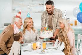 Free for commercial use no attribution required high quality images. Happy Man Holding Birthday Cakes With Candles Near Family Sitting At Kitchen Table Stock Photo Picture And Royalty Free Image Image 136058275
