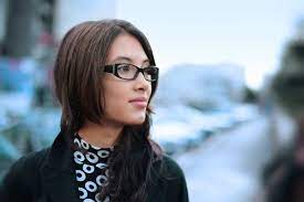 Cheerful mature woman wearing eyeglasses thinking with finger on chin. Top 5 Reasons People Hate Wearing Eyeglasses Omni Eye Specialists