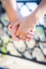 Adorable Couple Holding Hands While Showing Off Their Prized Engagement Rings Couple Holding Hands Cute Couples Engagement Rin
