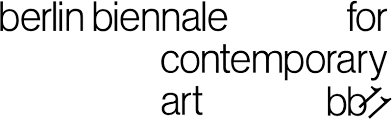 Indoor portrait of successful young woman with long dark hair wearing blue jacket posing with folded arms over yellow wall. 11th Berlin Biennale For Contemporary Art