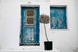 Looking for a good deal on shutter window? Facade Of White Building With Blue Door And Shutters In Rustic Style Tree Concrete Stock Photo 218692762