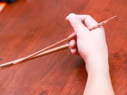 First, pick up a single chopstick, sandwiching it between your thumb and your index finger, as you would a pen. 3 Ways To Eat With Chopsticks Wikihow