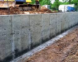Use a board to push the concrete firmly into the forms and up against the old foundation. Mccain Construction Poured Foundation Walls