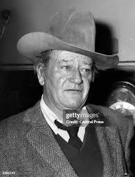Headshot promotional portrait of American actor John Wayne, smiling... News  Photo