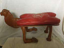 It is in the shape of the camel saddles. Antique Camel Saddle Foot Stool Seat Bench Hand Carved Camel Head Leather Seat 1792300730