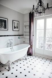 Classic marble tile contrasts with a pure white porcelain freestanding tub, while dark gray curtains and silver accent table give depth and richness. 10 Must See Parisian Bathroom Decor Ideas