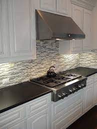 Black Pearl Leather Granite Countertops With A Mosaic Backsplash And White Painted Cabinets Granite Countertops Kitchen Kitchen Design Diy Kitchen Backsplash