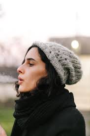 Brunette Woman Blowing A Cigarette Smoke Outdoor" by Stocksy Contributor "Marija  Kovac"