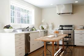 Concrete floors with pale marbled island, floor to ceiling glass windows, skylight, and central island. Reclaimed Wood Kitchen Island Transitional Kitchen Ashley Goforth Design