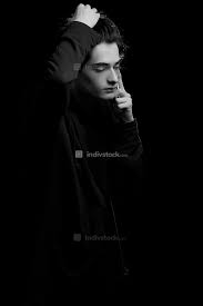 Download black wallpapers from pexels. Young Guy In A Black Hoodie On A Black Background With A Mobile Phone In His Hands People Indivstock
