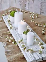centre de table pour la decoration une planche recup peinte en blanc de la mousse dans des petits vases blancs des boug deco noel decoration noel noel vert