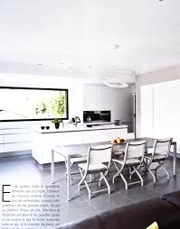 Une Cuisine Blanche Parfaitement Integree Dans Les Murs Et Autour De La Grande Fenetre Panoramique Ilot Amenagement Maison Fenetre Panoramique Salle A Manger