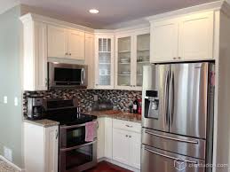 Cute White Shaker Kitchen With An Island With Barstool Seating Glass Cabinets And Crown Molding C Kitchen Design Shaker Kitchen Cabinets White Shaker Cabinets