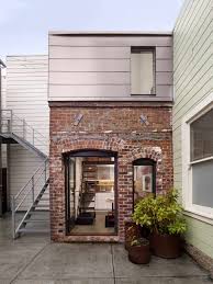 Brick work facade as well as privacy and noise reduction. Tiny Industrial Style Guest House Conversion
