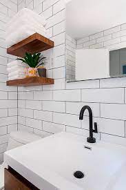 The bathtub of volcanic limestone and resin is by victoria + albert, and a ladder shelf keeps towels at a hand's reach. 333 East 14th Street Myhome Design Remodeling Small Bathroom Remodel Bathroom Black Fixtures Nyc Bathroom