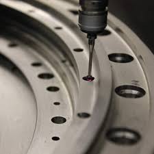 정밀한 루비 팁이 달린 프로브 헤드가 복잡한 엔진 블록의 구멍 위치와 평면도를 측정하는 브릿지 타입 CMM의 모습