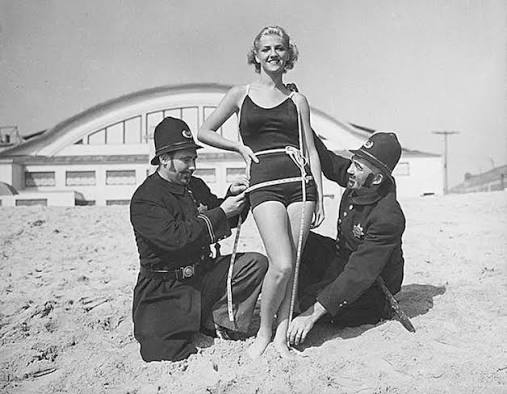 Measuring Bathing Suits 1920 - Policemen measure a woman in a bathing suit circa 1920