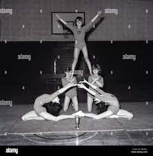 1960er Jahre, ein Bild aus der Mitte der 60er Jahre von fünf jungen  weiblichen künstlerische Turnerinnen zeigen ihre Talente in der Schule  Sporthalle und mit einer Trophäe, die Sie auf der Matte
