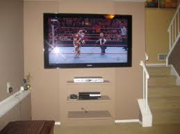 Onun tv'si 70 inç ve duvara monte etmiş. Televizyonu Braket Olmadan Asabilirsiniz Duz Paneller Icin Egimli Konsollar Tv Yi Duvara Nasil Yerlestirirsiniz