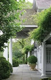 Wisteria Hangs From A Pergola And Clouds Of Boxwood Frame Back Terrace Chartotte Moss Hamptons Home Outdoor Gardens Beautiful Gardens Outdoor