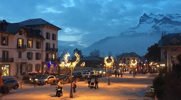 Place du centre de Saint-Gervais-les-Bains illuminée au crépuscule avec le massif du Mont-Blanc en arrière-plan