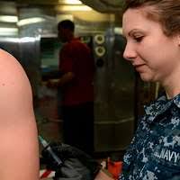 Senior Chief Aviation Boatswain's Mate (Handling) Jared Mueller, assigned  to the Wasp-class amphibious assault ship USS Essex (LHD 2), hugs his  children before Essex leaves for a deployment.