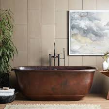 Freelance blogger sit at wood chair, work on laptop computer, type text for travel blog. Santorini Hammered Copper Soaking Tub Native Trails