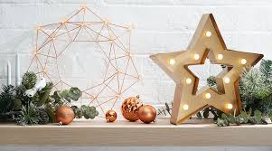 Relaxing armchair with a merry wall art. Shine Bright Festive Christmas Lighting Kmart