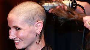 Volunteers shave their heads to show their support for cancer patients