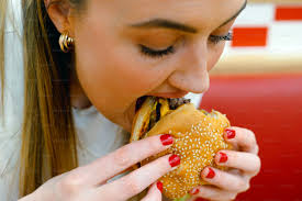 Person in pink shirt holding bread photo