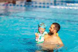 Dad Teaches A Little Daughter To Swim In The Pool Swimming Pools Pool Swimming