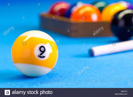 It is played on a rectangular billiard table with pockets at each of the four corners and in the middle of each long side. Billard Pool Spiel 9 Ball Mit Cue Und Nineball Kugeln Oben Am Billardtisch Mit Blauem Tuch Set Stockfotografie Alamy