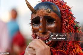 A person dressed for a masquerade, wearing an ancient mask, takes... News  Photo