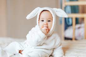 Premium Photo Small Child Smiling Baby In A White Bunny Rabbit Costume Easter Playing With Colourful Eggs
