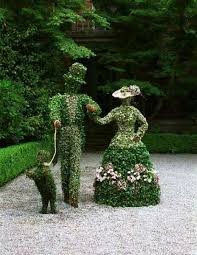 A Topiary Couple Walking Their Dog Along The Garden Path Topiary Garden Garden Art Garden Art Sculptures