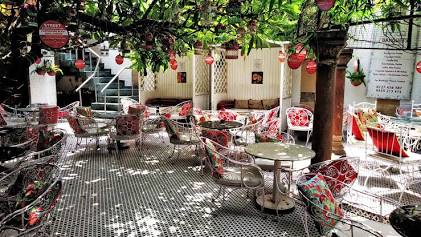 The lush, bohemian outdoor courtyard at Cappuccino Blast, AI generated