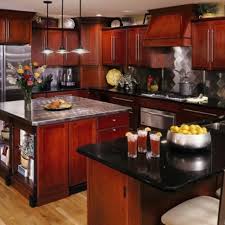 Rich burgundy stained cherry cabinets and black absolute granite countertops, offset by beige floor and backsplash tiles give this space a royal feel. Cherry Cabinets Black Granite Cherry Cabinets Kitchen Cherry Wood Cabinets New Kitchen Cabinets