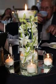 Love The Floating Candle With Submerged Orchid As An Idea For One Of The Centerpieces Orchid Centerpieces Floating Candle Centerpieces Wedding Centerpieces
