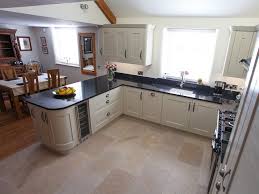 Sleek kitchen units and bar stools make this space both practical and stylish. Ashbourne Stone Buxton Woodworks