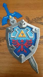 Et Voila Une Version Legerement Readaptee Du Bouclier Et De L Epee De Link Zelda En Perles Hama Hama Beads Design Perler Bead Art Pearl Beads Pattern