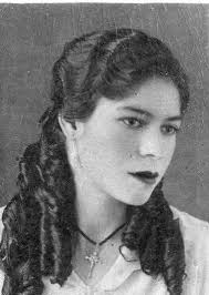 My mawmaw is in the middle. She was born 1900 . Had 7 children. The photo  is black and white but her hair was fire engine red