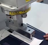 Máy bổ trụ và đục khuyết trong sản xuất áo polo