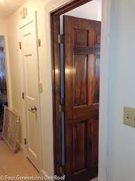 White front door decoration with plants, outdoor lights and a green wreath. How To Paint Dark Stained Doors Before After Four Generations One Roof