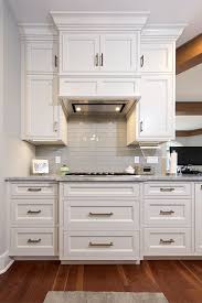 White Kitchen Cabinets And Glass Subway Tile Backsplash Behind Cooktop Whitecabinets Customcabinets Kitchen Remodel Kitchen Custom Kitchen