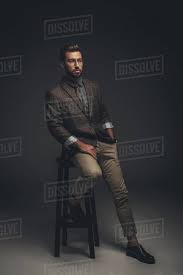 Maybe you would like to learn more about one of these? Sophisticated Young Man In Suit And Glasses Sitting On Bar Stool Stock Photo Dissolve