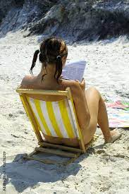 Nude girl reading on beach Stock Photo | Adobe Stock
