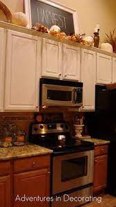 Keeping decor objects similar in style and color help create a simpler and more impactful visual when decorating above cabinets. 42 Best Decor Above Kitchen Cabinets Ideas Above Kitchen Cabinets Decor Above Kitchen Cabinets Kitchen Cabinets Decor