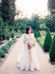 Stylish young groom and bride with wedding bouquet standing together in botanical garden. High School Sweethearts Spring Garden Wedding Ruffled