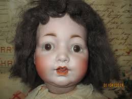 What is the identity of this antique German doll with a bisque head and  paper mache body?