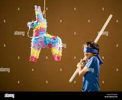 Con los ojos vendados boy con bastón y pinata Fotografía de stock - Alamy